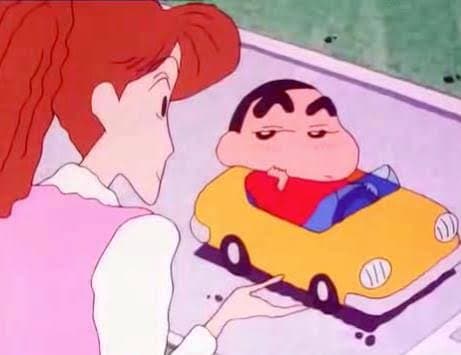 Shin-chan sitting cool in a yellow toy car